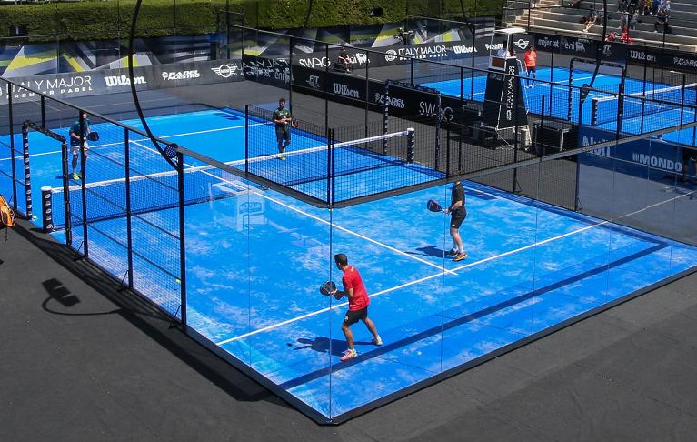 Campo da padel con giocatori in azione, un esempio di ambiente sportivo dove prevenire infortuni con tecniche osteopatiche